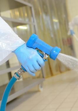 Worker in factory perferming hygiene cleaning activities